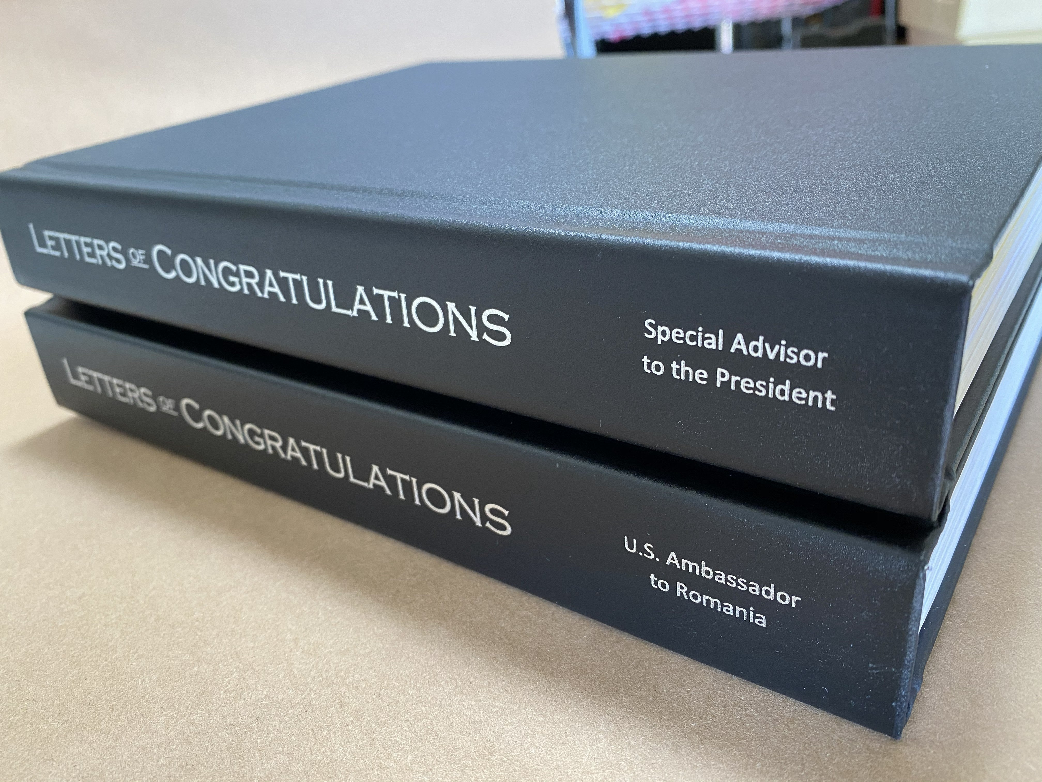 Two navy custom hardcover books titled Letters of Congratulations with white spine text, bound by 4everBound from printed pages